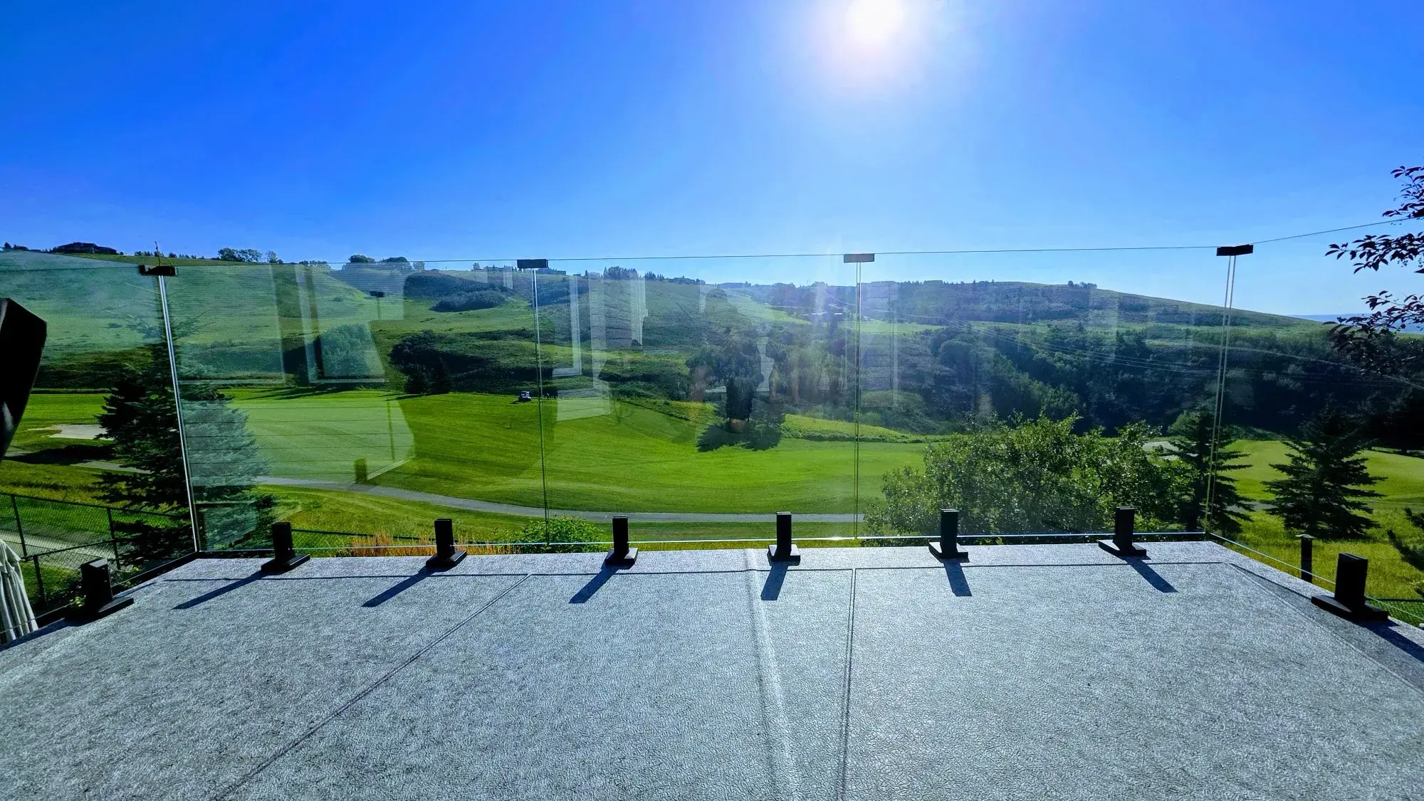 A deck re-skinned in vinyl, finished surface running to the glass railing